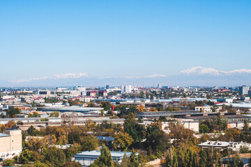 View of Tashkent, the outskirts of the city, the country of Uzbekistan. View of the mountains and residential buildings from the window. Sunny day.