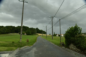 Route de campagne sous un ciel d'orage au bourg de Champagne au Périgord Vert 