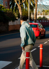 Boy crossing a pedestrian crossing, with car behind