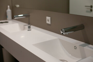 minimal faucet and sink in modern office public bathroom