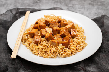 fried noodles with tofu on white dish