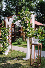 Wedding. Wedding ceremony. Arch. Arch, decorated with pink and white flowers standing in the woods, in the wedding ceremony area