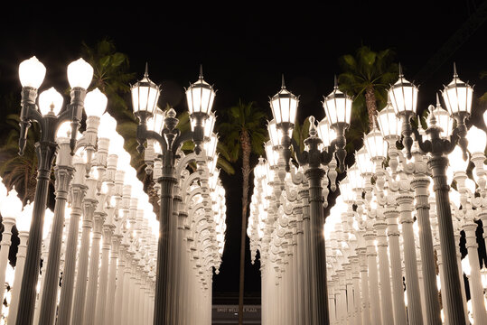 Los Angeles, United States - November 17, 2022: A picture of Urban Light, a public art designed by Chris Burden and unveiled in 2008, next to the Los Angeles County Museum of Art, at night.