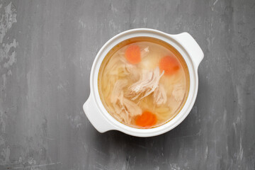 bowl of chicken broth with chicken and carrot in ceramic