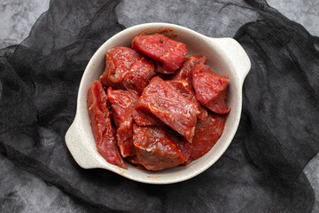 Fresh raw cube of beef in white bowl