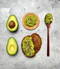Sandwich with rye bread with cereal and avocado on light background, ingredients. Top view, flat lay.