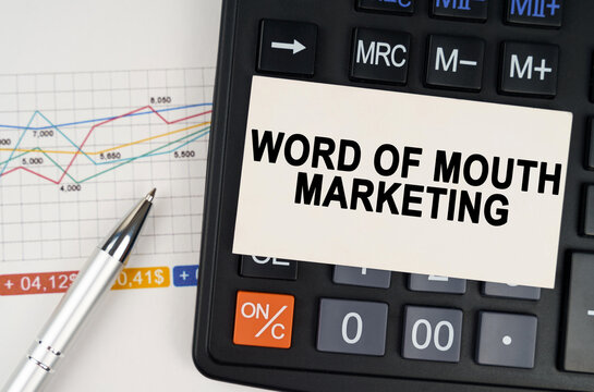 On the business chart lies a pen, a calculator and a business card with the inscription - Word of Mouth Marketing