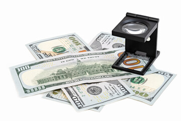 Magnifying glass on dollars. A shot of a loupe on 100 dollars bills.
