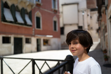 Portrait of handsome boy on the empty streets of Venice on a sunny day in 2021