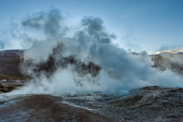 Fototapeta premium Steaming vent on the El Tatio geyser field in the high Andes of northern Chile in the blue hour before sunrise 