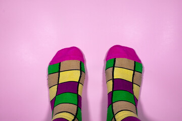 Rainbow of checkered socks on a pink background