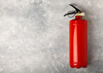 Fire extinguisher on the background of a black texture wall. Red fire extinguisher indoors on the...