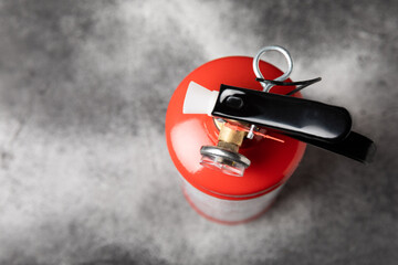 Fire extinguisher on the background of a black texture wall. Red fire extinguisher indoors on the...