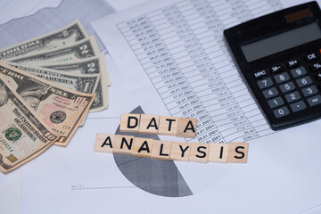Obraz premium the inscription Data analysis next to dollars, calculator and financial data. Analyzing financial data in the enterprise