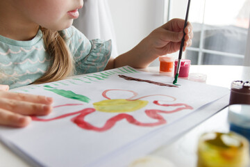 Little child draws with watercolor, concept of education in the kindergarten