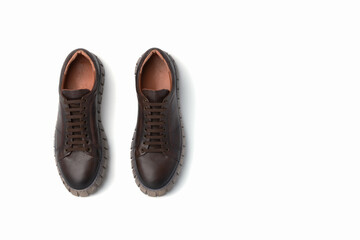 Dark brown leather men's sporty boots with thick soles on a white background. Copy space.