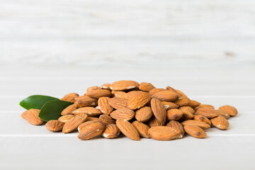 Close-up of Almonds nuts with leaves on table background. Top view. Flat lay