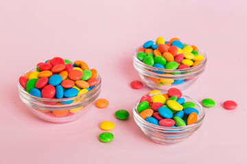 Multicolored candies in a bowl on a colored background. birthday and holiday concept. Top view with copy space