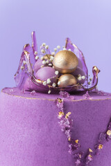 Wedding cake with violet cream cheese frosting decorated with caramel vase and golden chocolate...