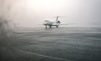 Lonely small aircraft during the shower rain in the airport Kyiv Zhuliany, Ukraine