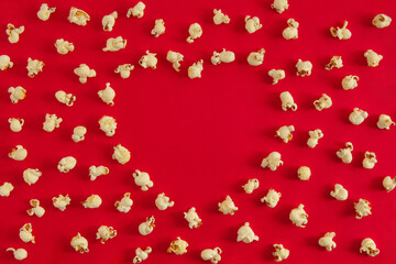 Valentines day heart shaped concept out of popcorn on bright red background. Minimal flat lay.