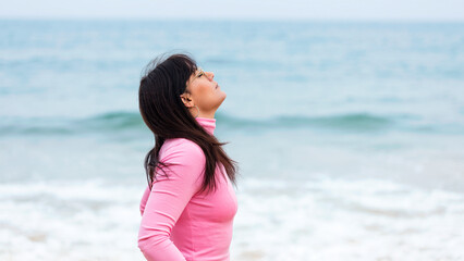 woman breathing in front of the sea on vacation. Woman breathing fresh air on the beach. Woman...