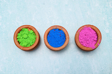 top view of colorful traditional holi powder in bowls isolated on dark background.Space for text . happy holi.Concept Indian color festival called Holi