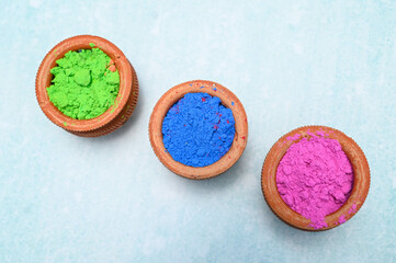 top view of colorful traditional holi powder in bowls isolated on dark background.Space for text . happy holi.Concept Indian color festival called Holi