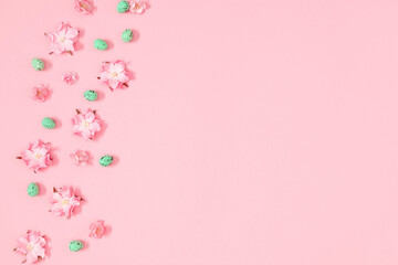 Easter decor, composition. Flowers, easter eggs on pastel pink background. Flat lay, top view, copy space 