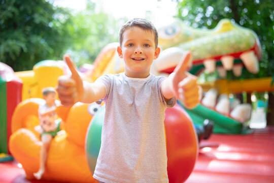 Happy boy having a lots of fun on a colorful inflate castle