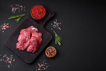 Raw beef cut into several pieces on a wooden cutting board