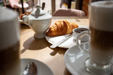 Morning mood: Breakfast croissant and coffee on the table in cafe.