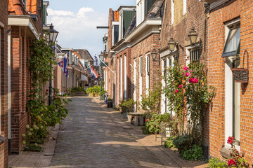 Fototapeta na wymiar Narrow street in the center of the picturesque village of Woudsen in the province of Friesland, Netherlands.