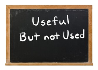 Useful but not used written in white chalk on a black chalkboard isolated on white