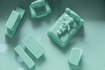 Abstract artistic figure of a person laying on bed with 3D objects all in monochromatic light blue 