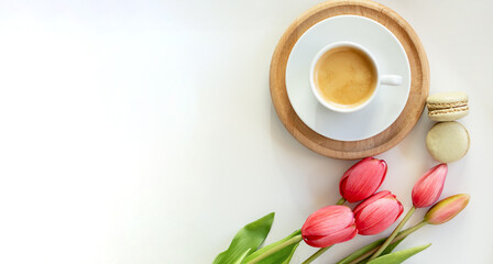 Fototapeta na wymiar A bouquet of white tulips, cup of coffee with a love note and envelope on white boards. .