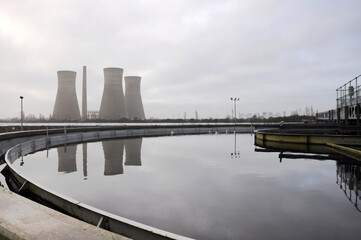 Abwasserbecken mit Spiegelung des Kraftwerks