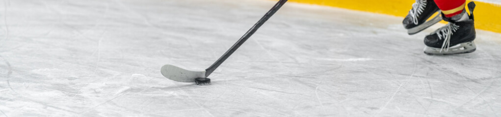 hockey player with a puck on a hockey stick in a game on ice. banner with copy space