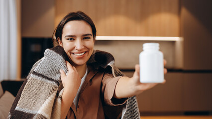 Happy young woman holding bottle of dietary supplements or vitamins in her hands. Close up. Healthy lifestyle concept