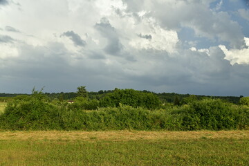 Fototapeta na wymiar Nuage d'orage en formation sur un paysage rural près du bourg de Champagne au Périgord Vert 