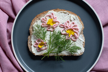 creative sandwich with soft cheese and pink pasta tarama greens, flowers