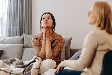 Sad frustrated woman talking in a session with a psychotherapist about her problems