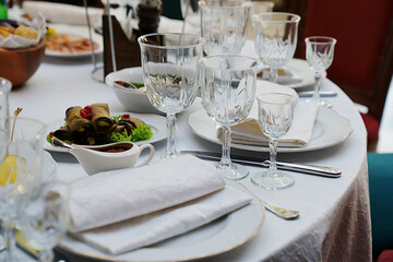 table setting for a festive dinner. empty wine glasses, tableware and snacks.
