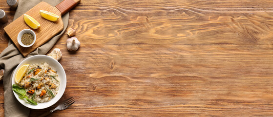 Plate with tasty seafood risotto on wooden background with space for text