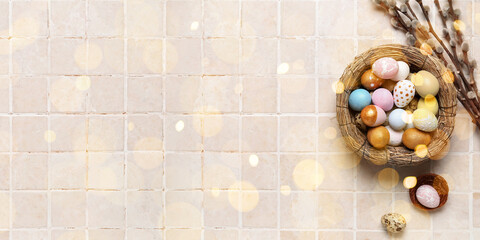 Nest with Easter eggs and pussy willow branches on light background with space for text