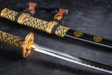 Japanese samurai katana sword and scabbard close up. Photo of a weapon in low key with selective...