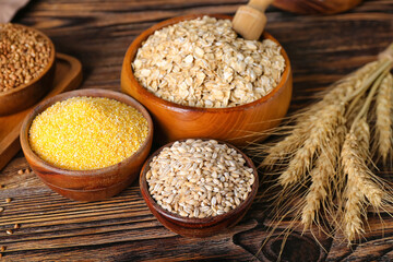Bowls with different cereals on wooden background
