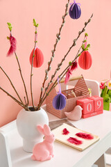 Beautiful Easter decor, notebooks and cube calendar on table near color wall in room, closeup