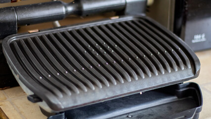 Black electric grill grate, textured background. The surface of the electric grill. Pollution of...