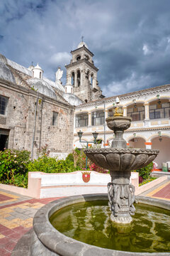 Interior gardens and patio of the Basilica of Ibarra, with tress, bushes, a fountain and walking corridors. Ibarra, Imbabura province, Ecuador.